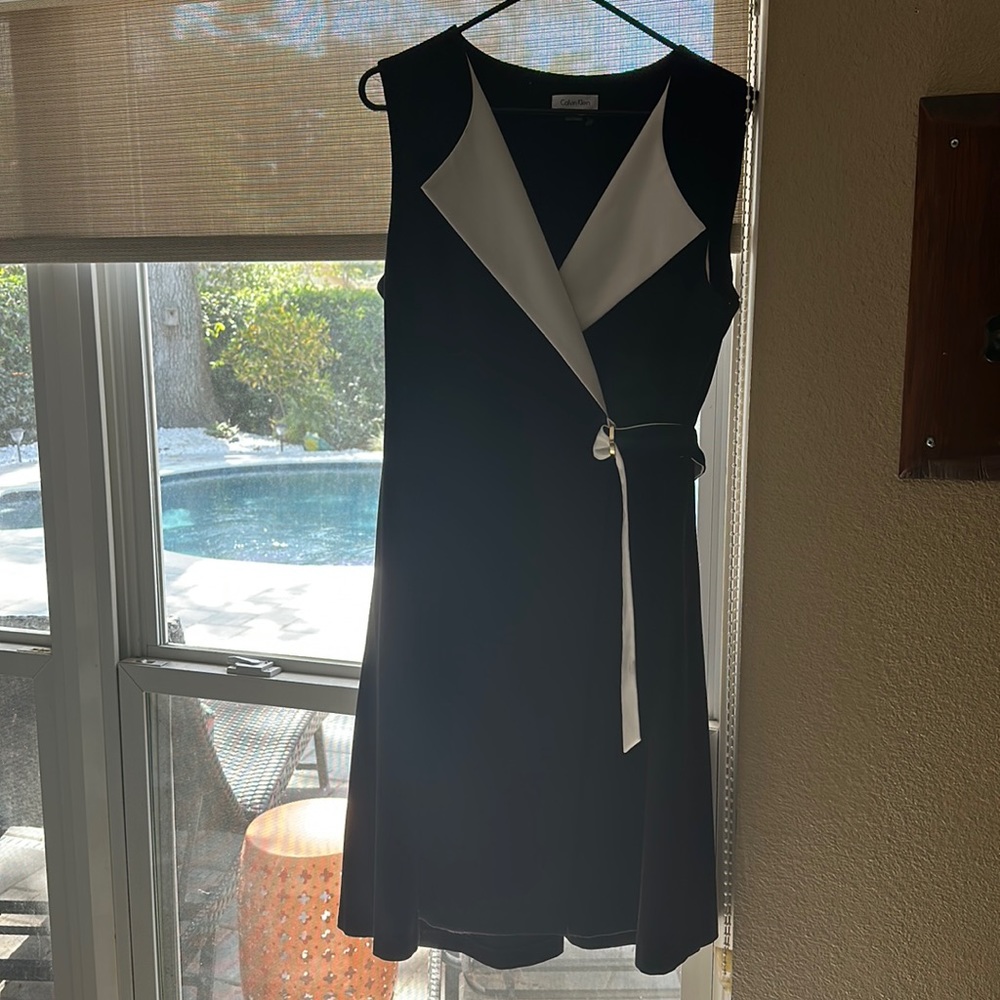 Sleek black and white sleeveless wrap style sheath.